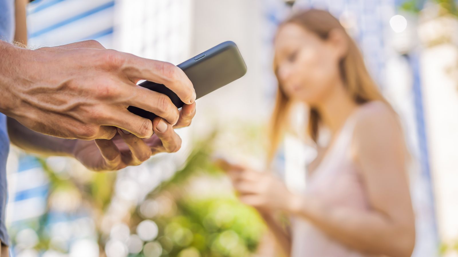 Dos persones consulten el seu mòbil