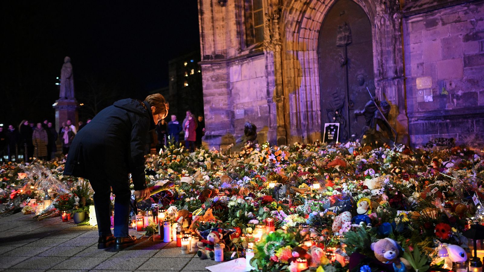 Una dona deixa flors i candeles en record de les víctimes de l'atemptat, este diumenge