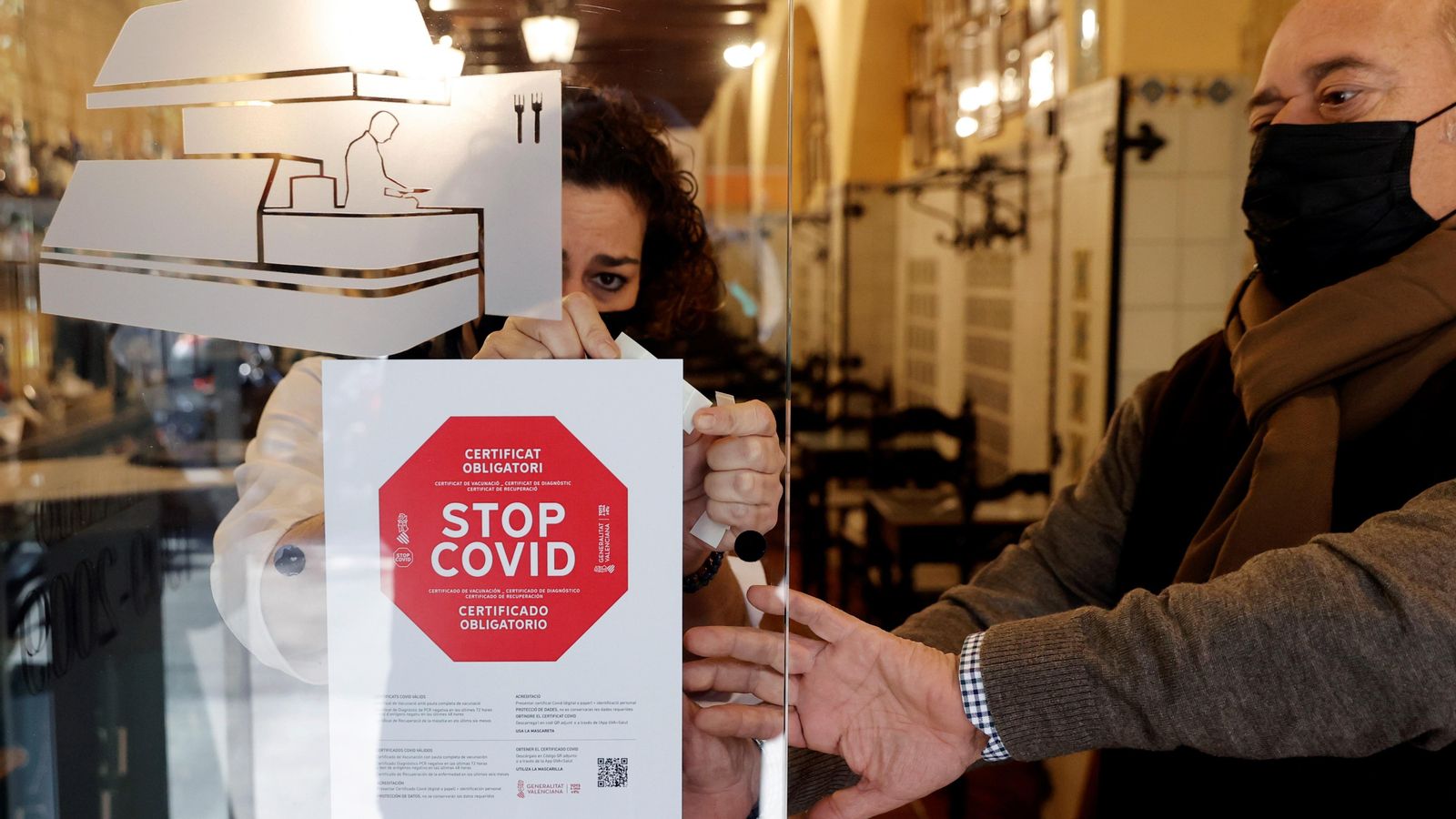 Personal col·loca un cartell a l'entrada del seu restaurant de València avisant de l'obligatorietat del passaport covid