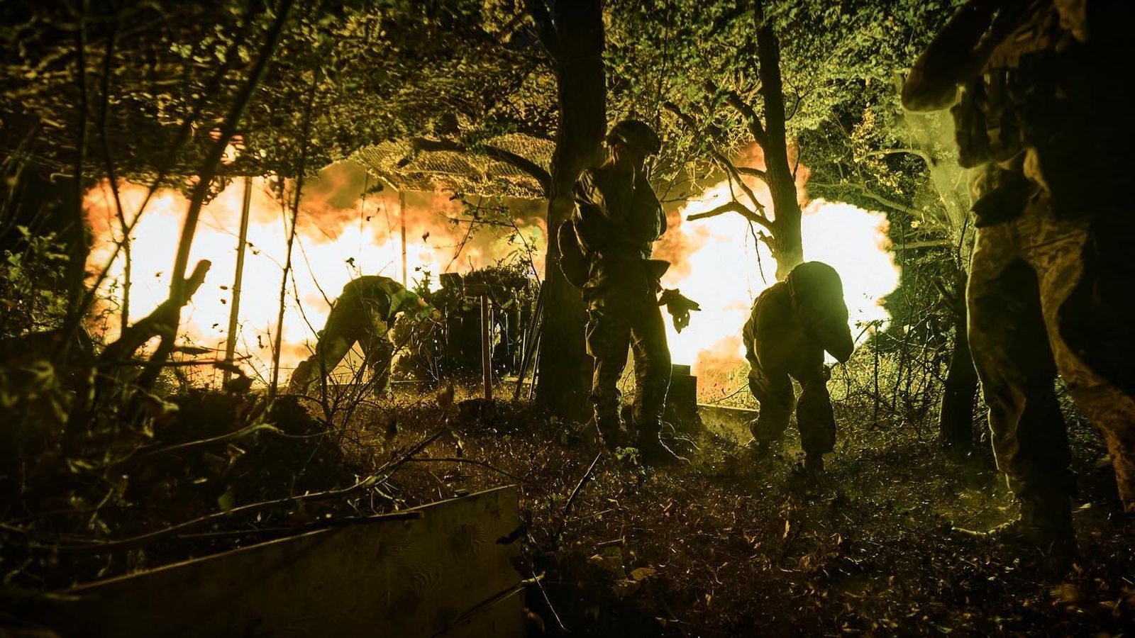 Soldats ucraïnesos protegeixen les seues oïdes amb les mans del soroll de l'artilleria pesant