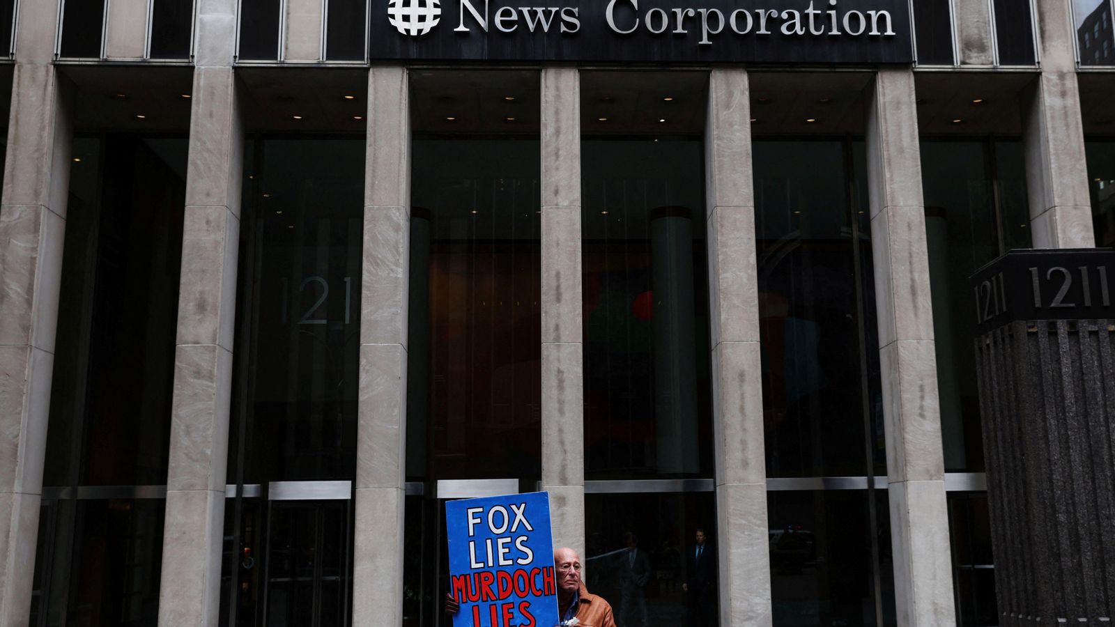 Un manifestant davant la seu de News Corporation a Nova York