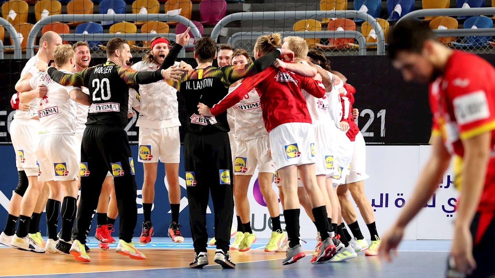 Els jugadors danesos celebren la victòria mentre un jugador espanyol es lamenta