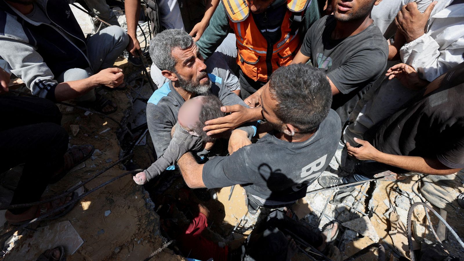 Un grup de palestins rescaten en cadàver d'un xiquet, mort en un bombardeig israelià en el camp de refugiats de Nuseirat (centre de Gaza)