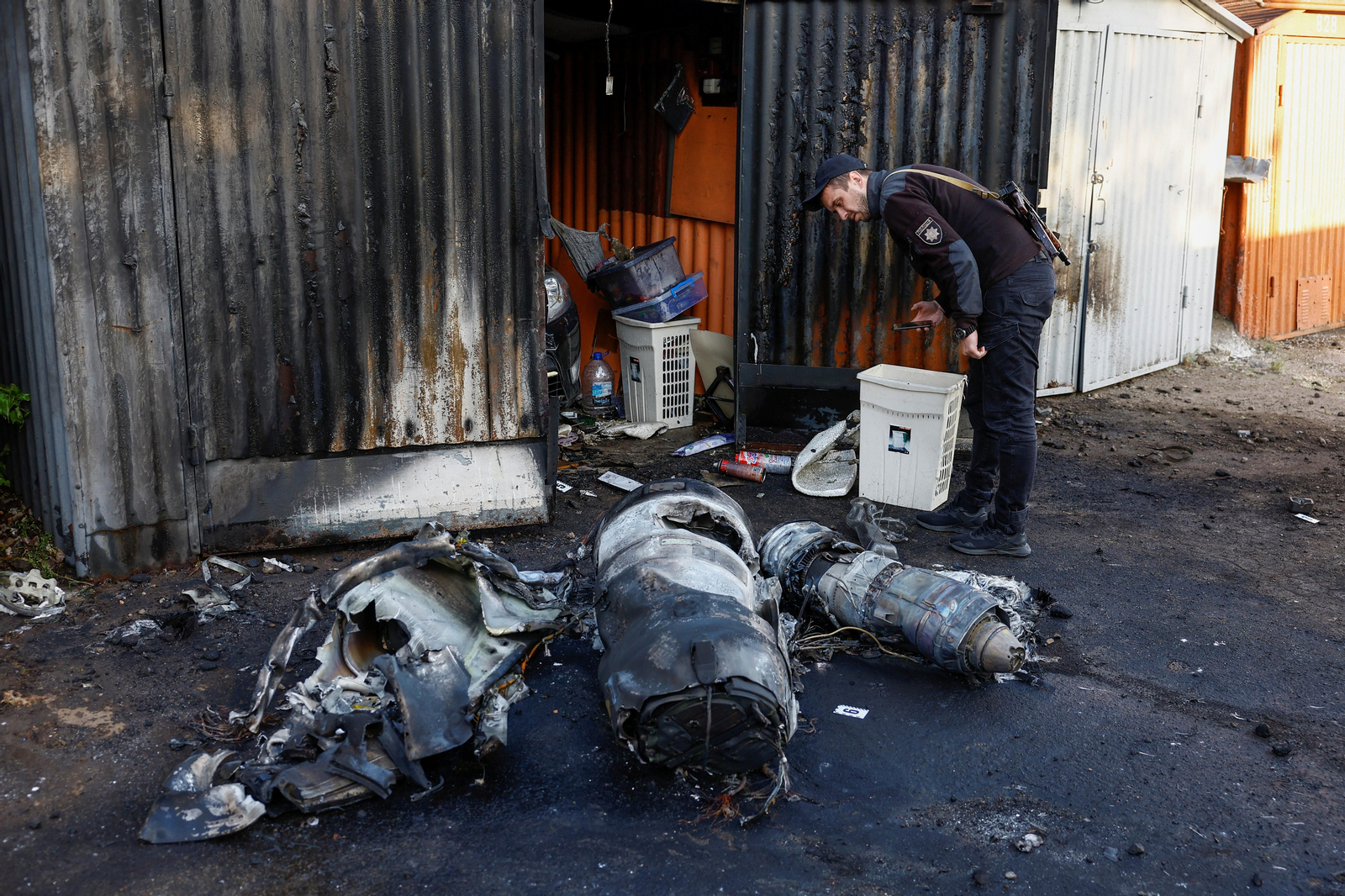 Un agent de policia de Kíiv inspecciona tres dels projectils disparats per Rússia