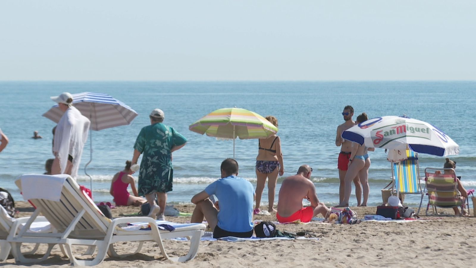 Un grup de turistes descansa en una platja a la Comunitat Valenciana