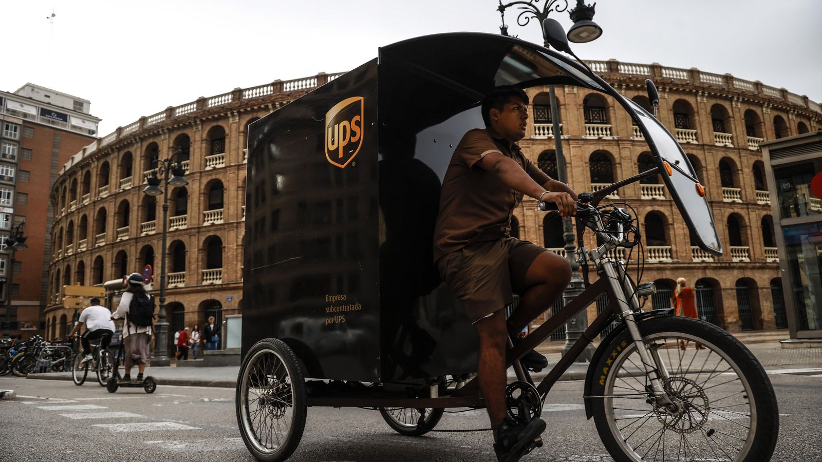 Un treballador d'UPS amb una bicicleta de repartiment a la ciutat de València