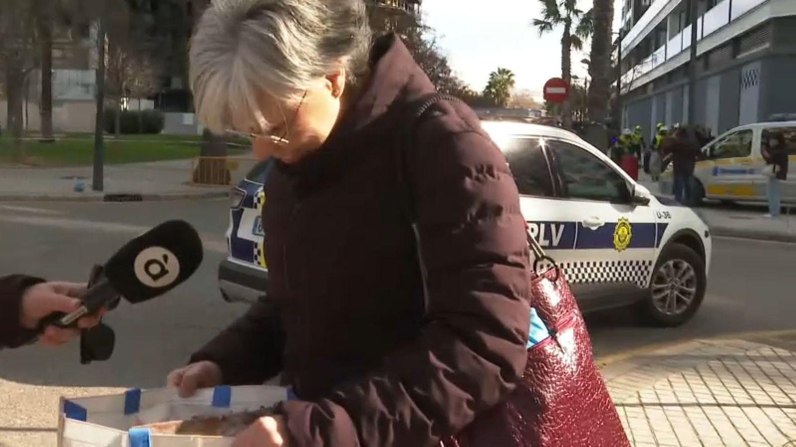 Una veïna de la finca de Campanar mostra el poc que s'ha recuperat de sa casa, un placa d'ordinador calcinada