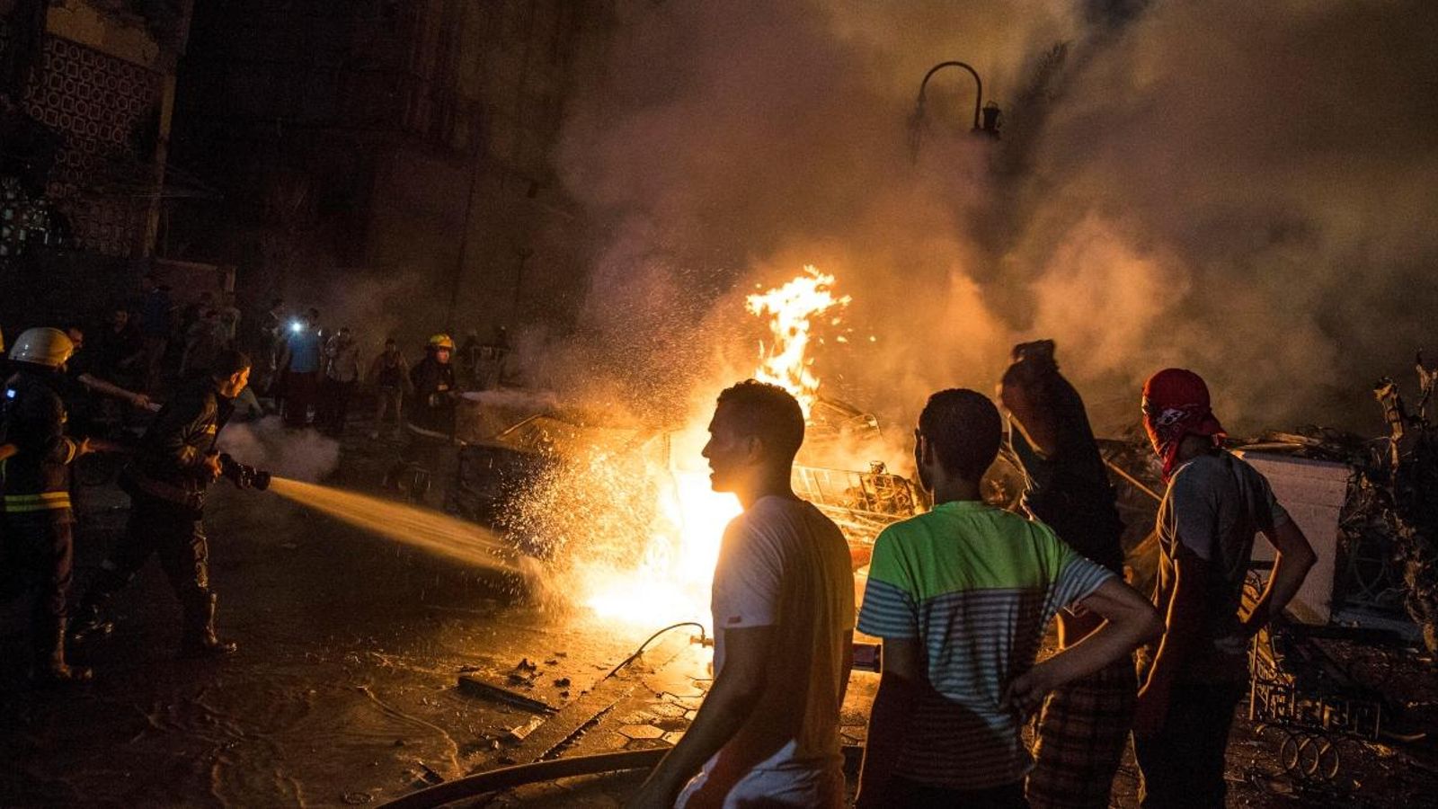 Els equips d'extinció treballen davant l’Institut Nacional del Càncer al Caire