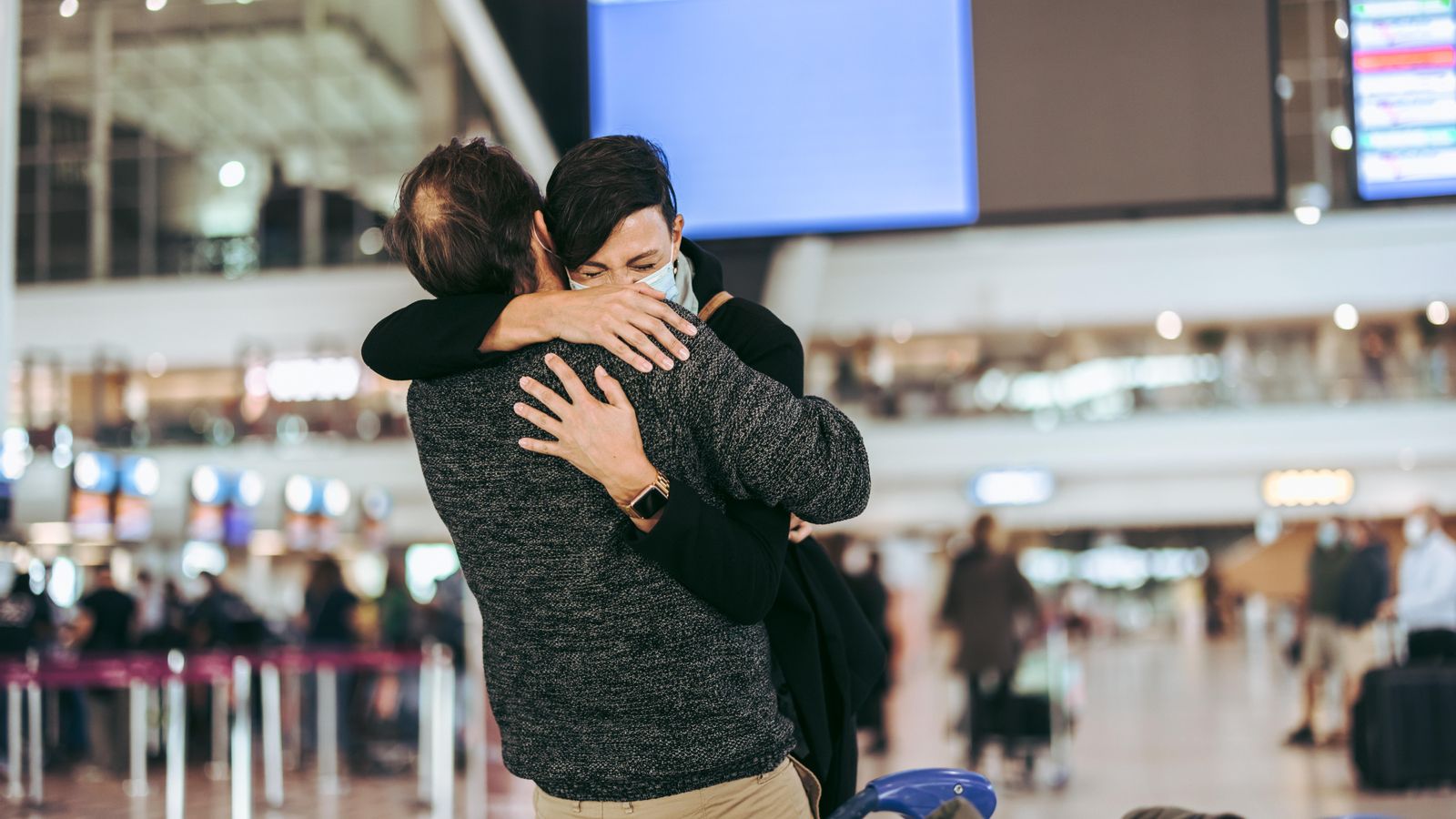 Dos persones s'abracen a un aeroport en una imatge d'arxiu