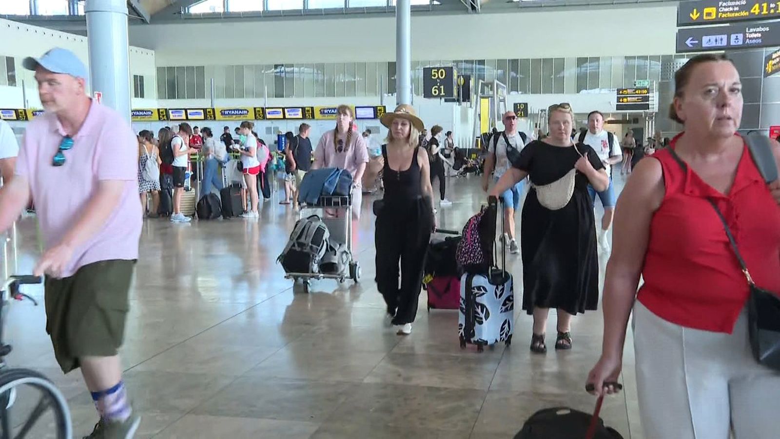 Viatgers per amb maletes a un aeroport