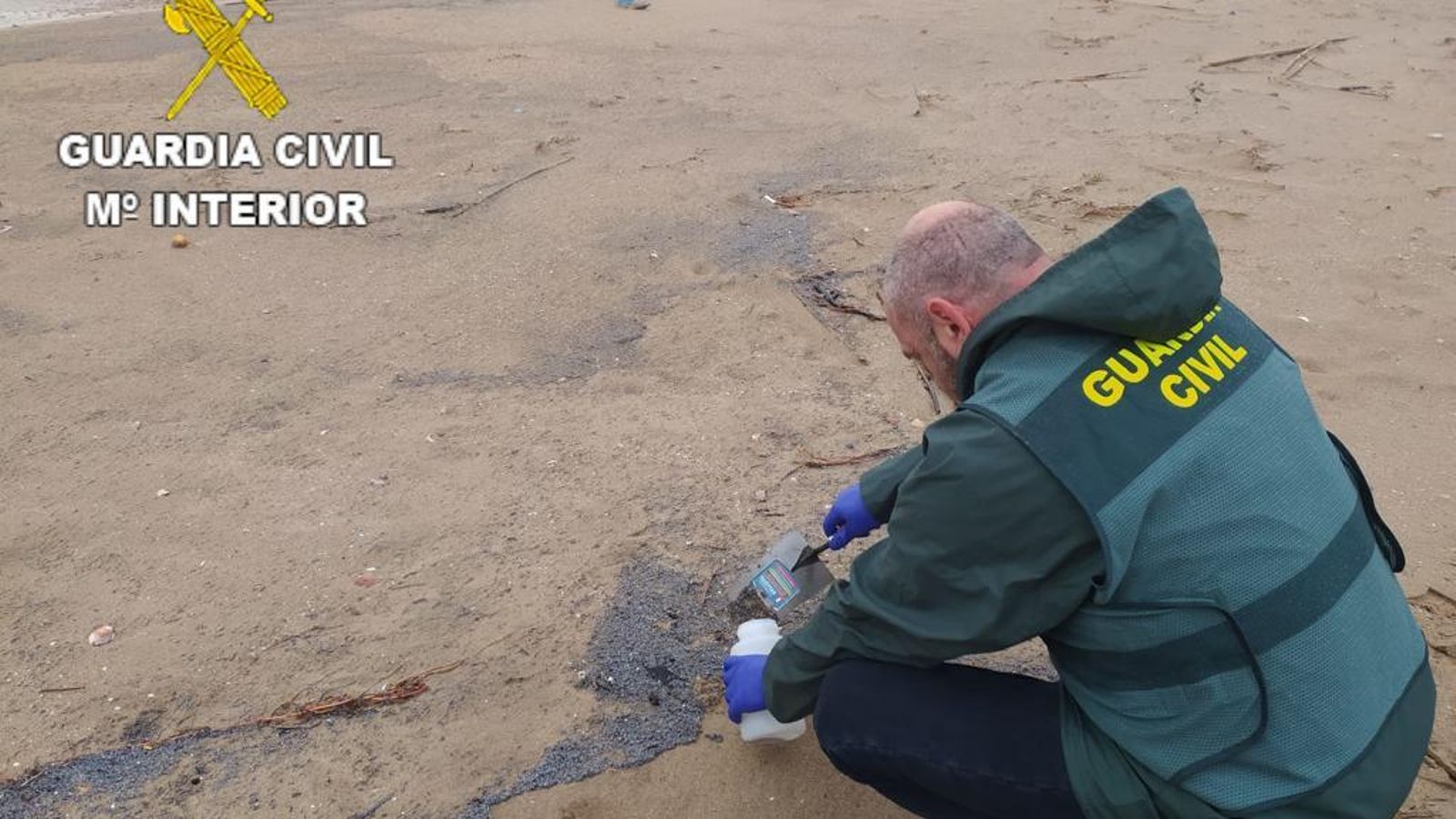 Un agent de la Guàrdia Civil arreplega mostres a una platja