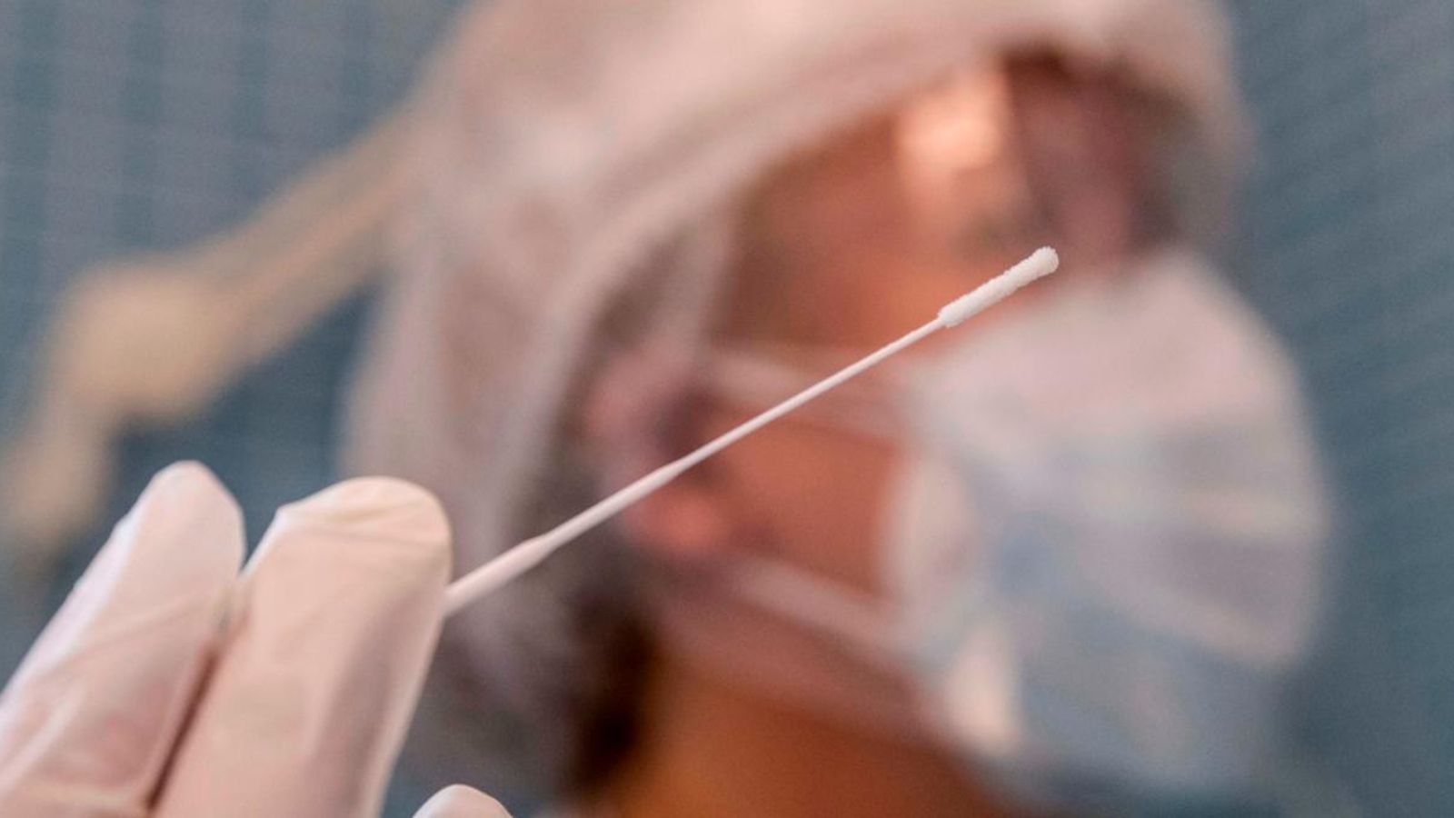 Una infermera sosté un bastoncillo mentre realitza una prova PCR.