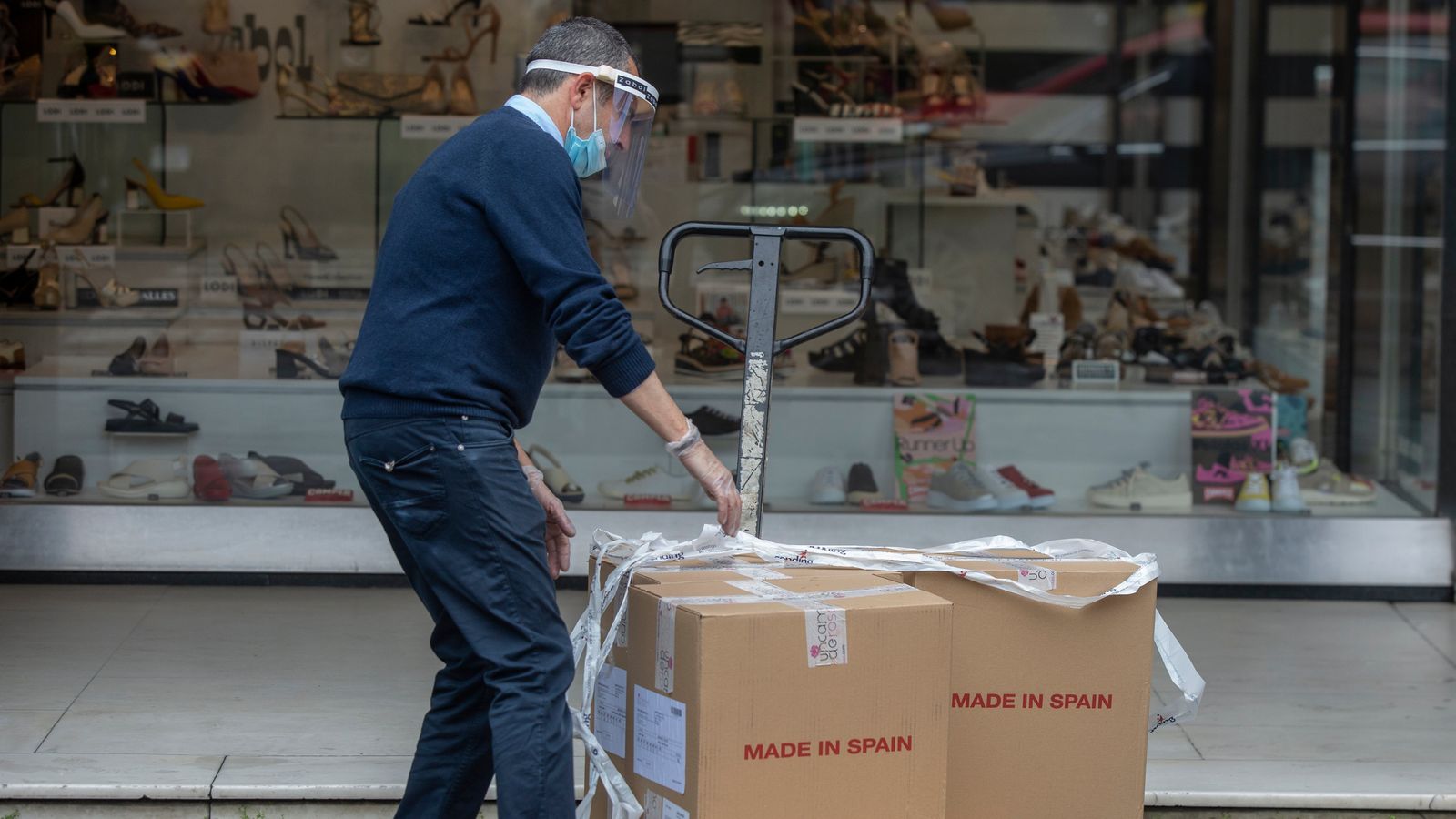 Un treballador descarrega mercaderia en una sabateria en imatge d'arxiu