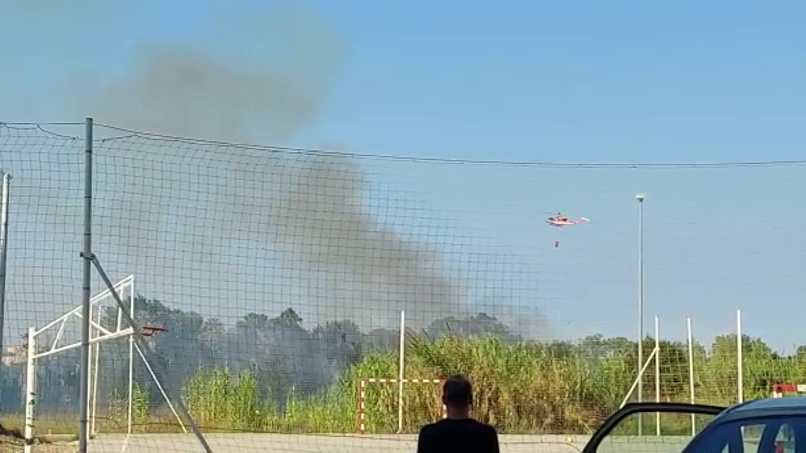Un helicòpter treballa en les tasques d'extinció de l'incendi de vegetació declarat a Oliva