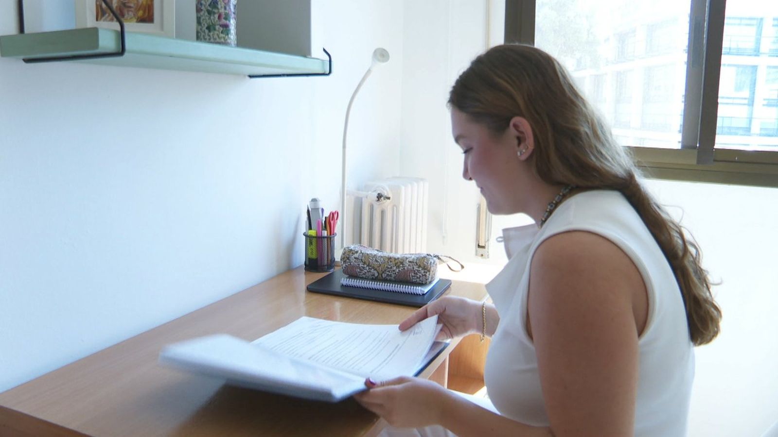 Una estudiant universitària en l'habitació que ha llogat per al curs en una residència