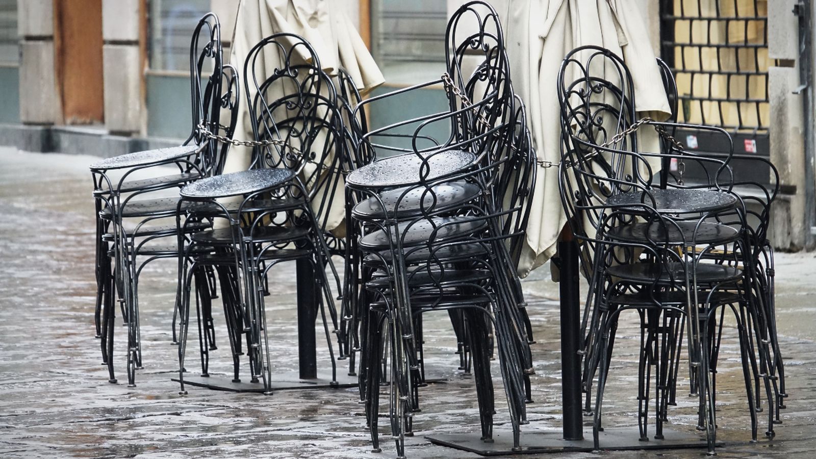 Cadires d'un restaurant apilades al carrer
