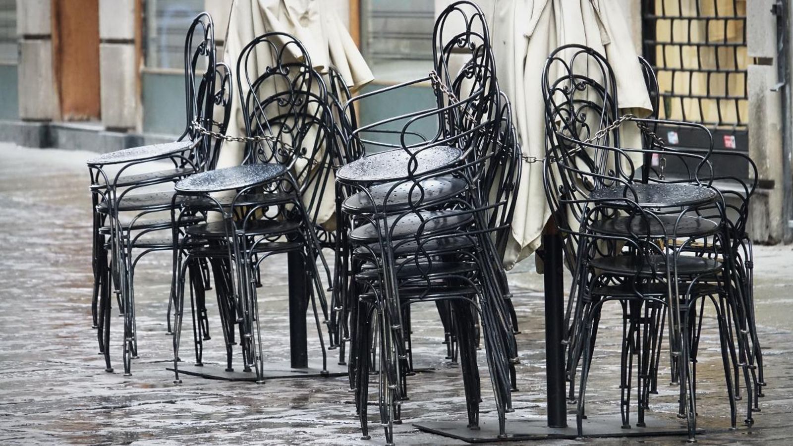 Cadires d'un restaurant apilades al carrer