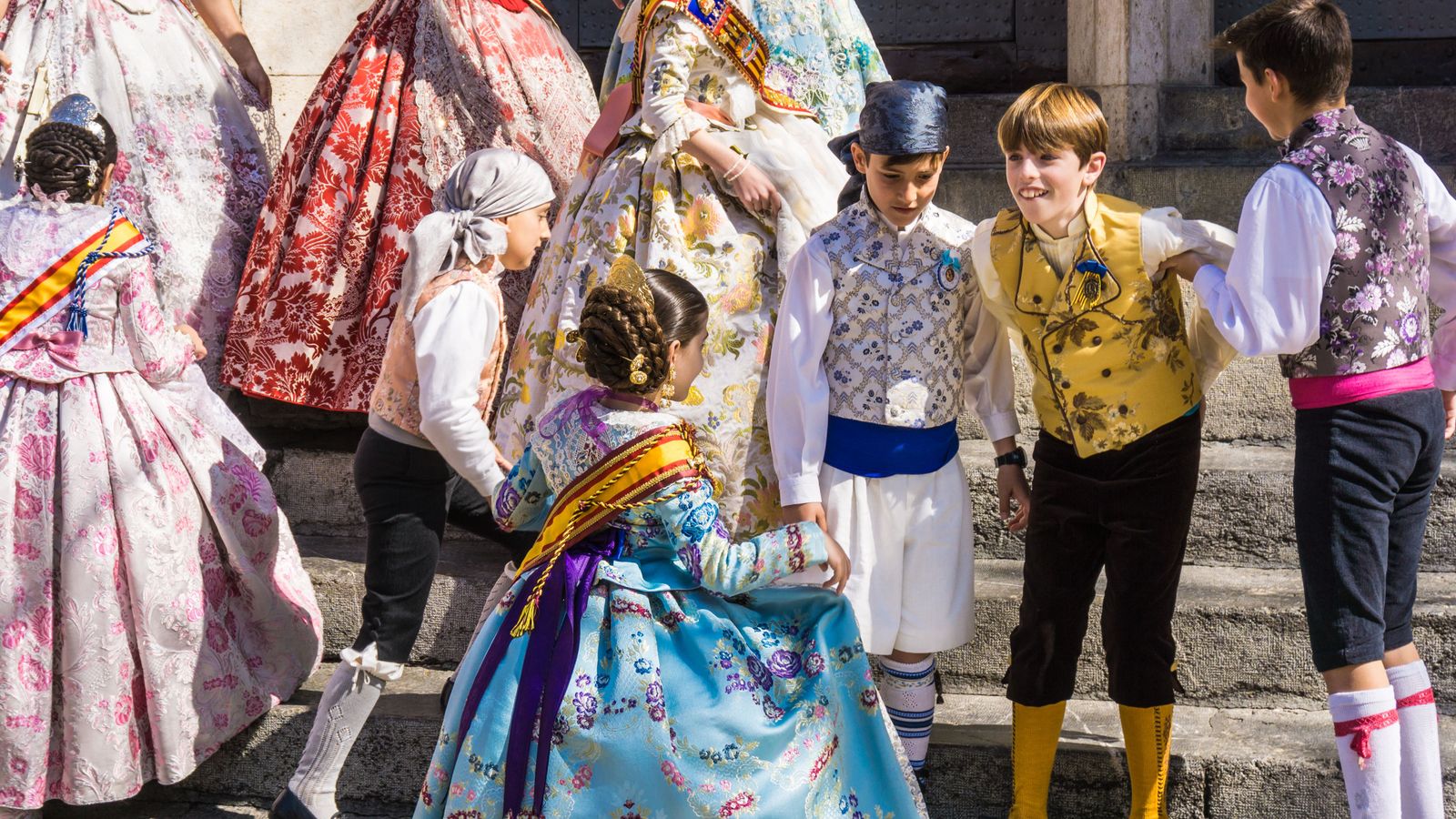 Un grup de xiquets, a les portes de la Llotja de València, durant els dies de Falles