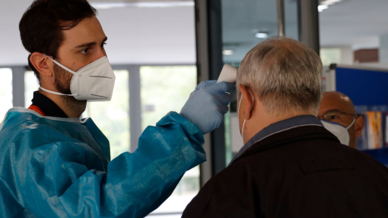 Personal sanitari pren la temperatura a un home.