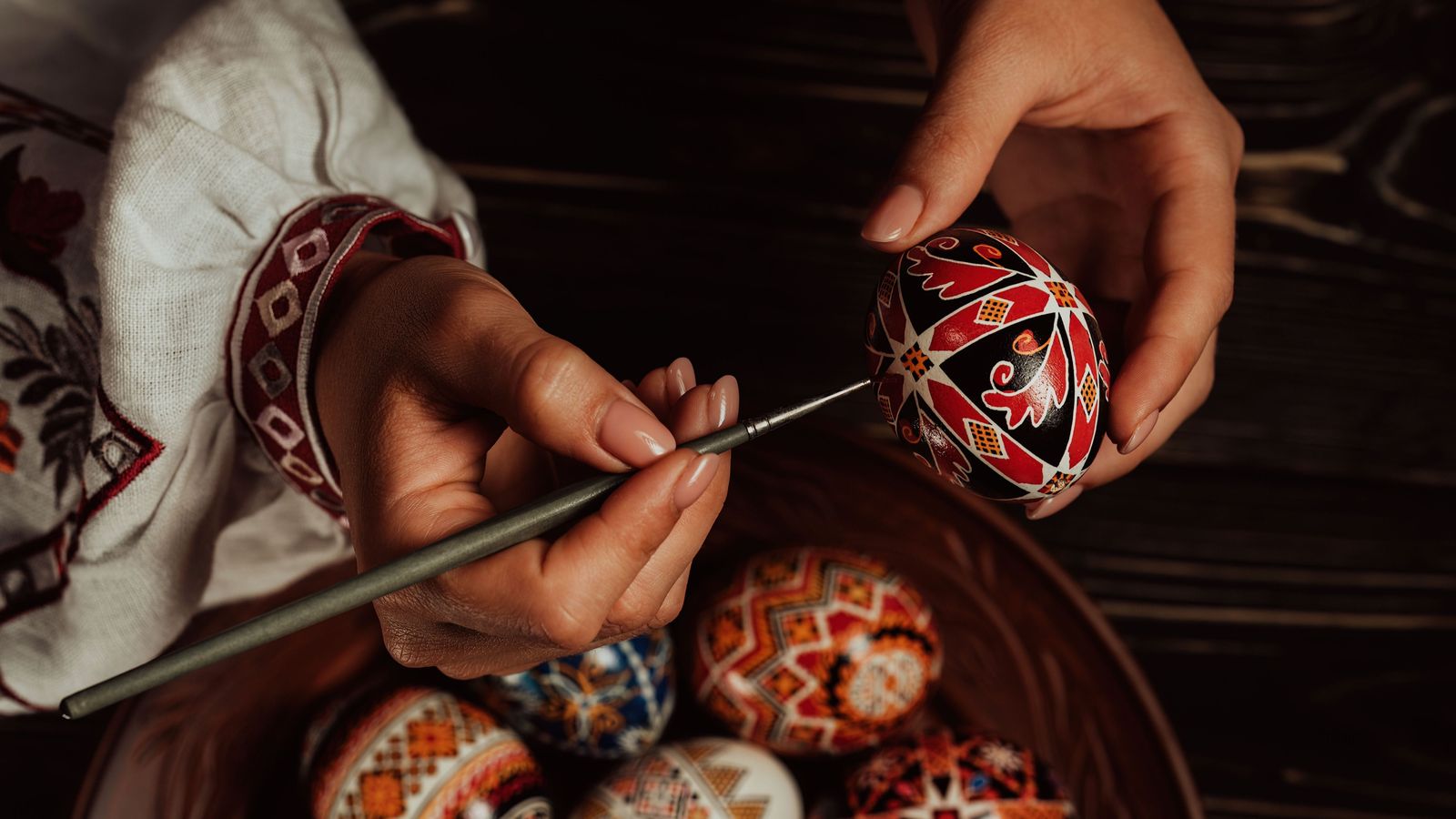 Una dona decora minuciosament, amb un pinzell, els ous que tradicionalment es fan a Ucraïna i Estònia per Pasqua
