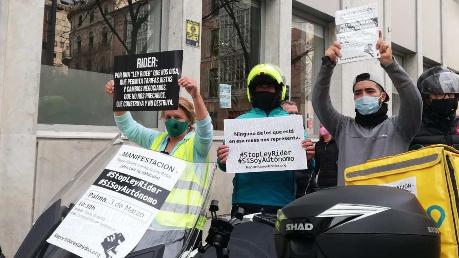 Repartidors a domicili amb cartells reivindicatius protesten contra la llei de 'riders'