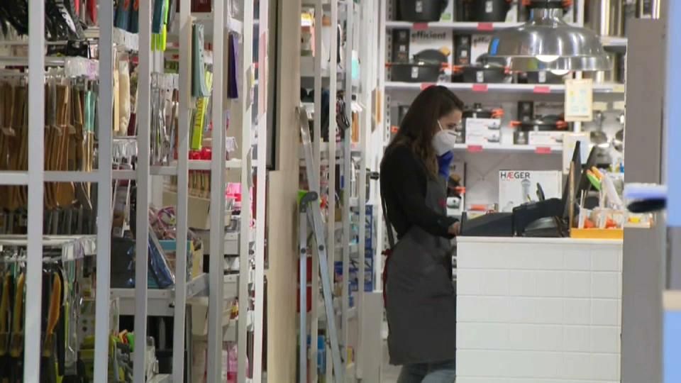 Una dependenta a l'aparador d'un comerç en una imatge d'arxiu Una dependenta a l'aparador d'un comerç en una imatge d'arxiu