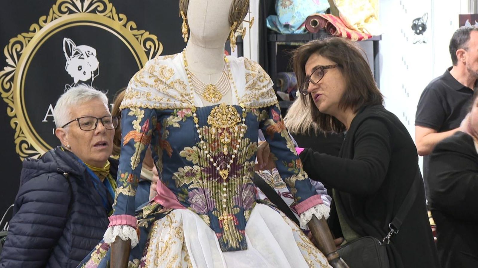 Dues dones miren un vestit de fallera a Espai Indumentària València