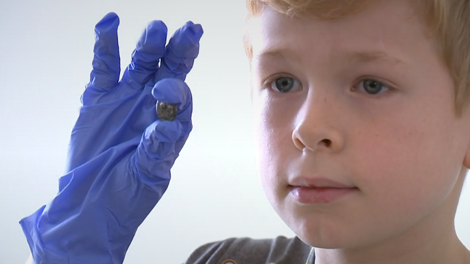 El xiquet posa amb el denari romà que va trobar