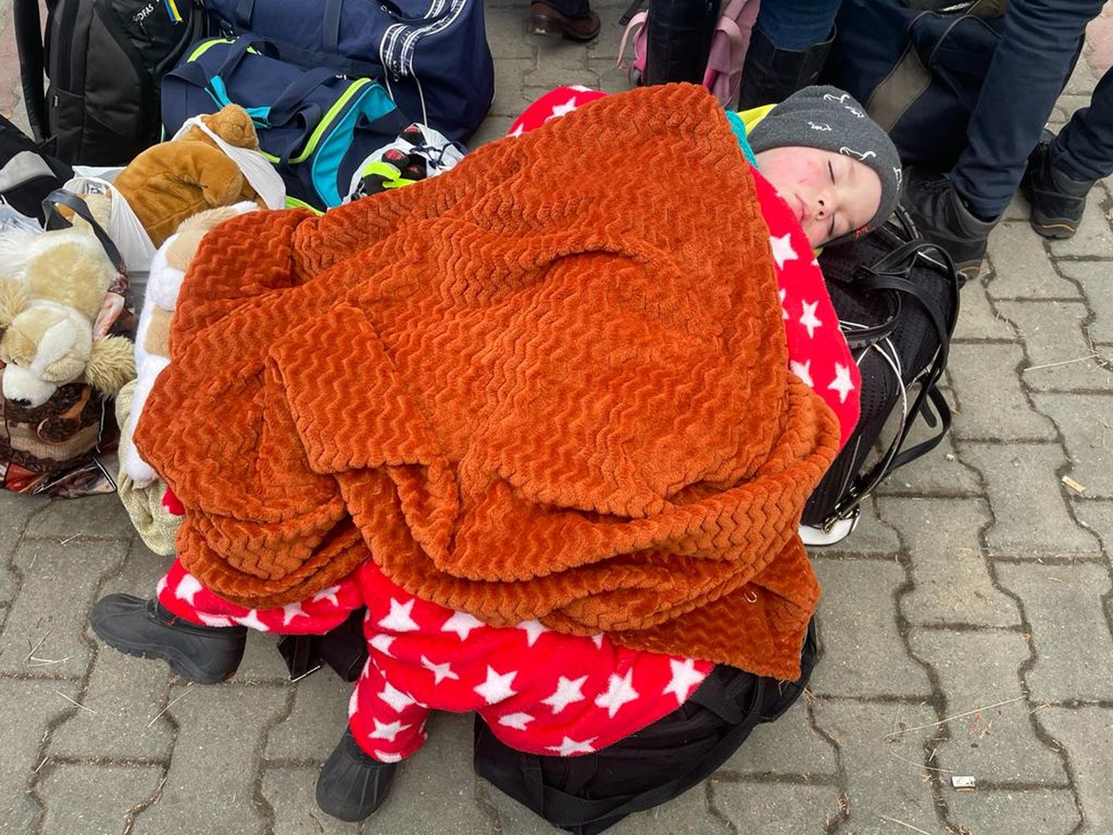 Un menut ucraïnés espera per a fugir tapat amb mantes i envoltat de maletes