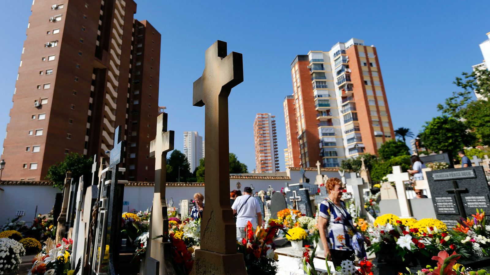 Diverses persones passegen aquest dimarts festivitat de Tots els Sants pel cementeri de Benidorm /
