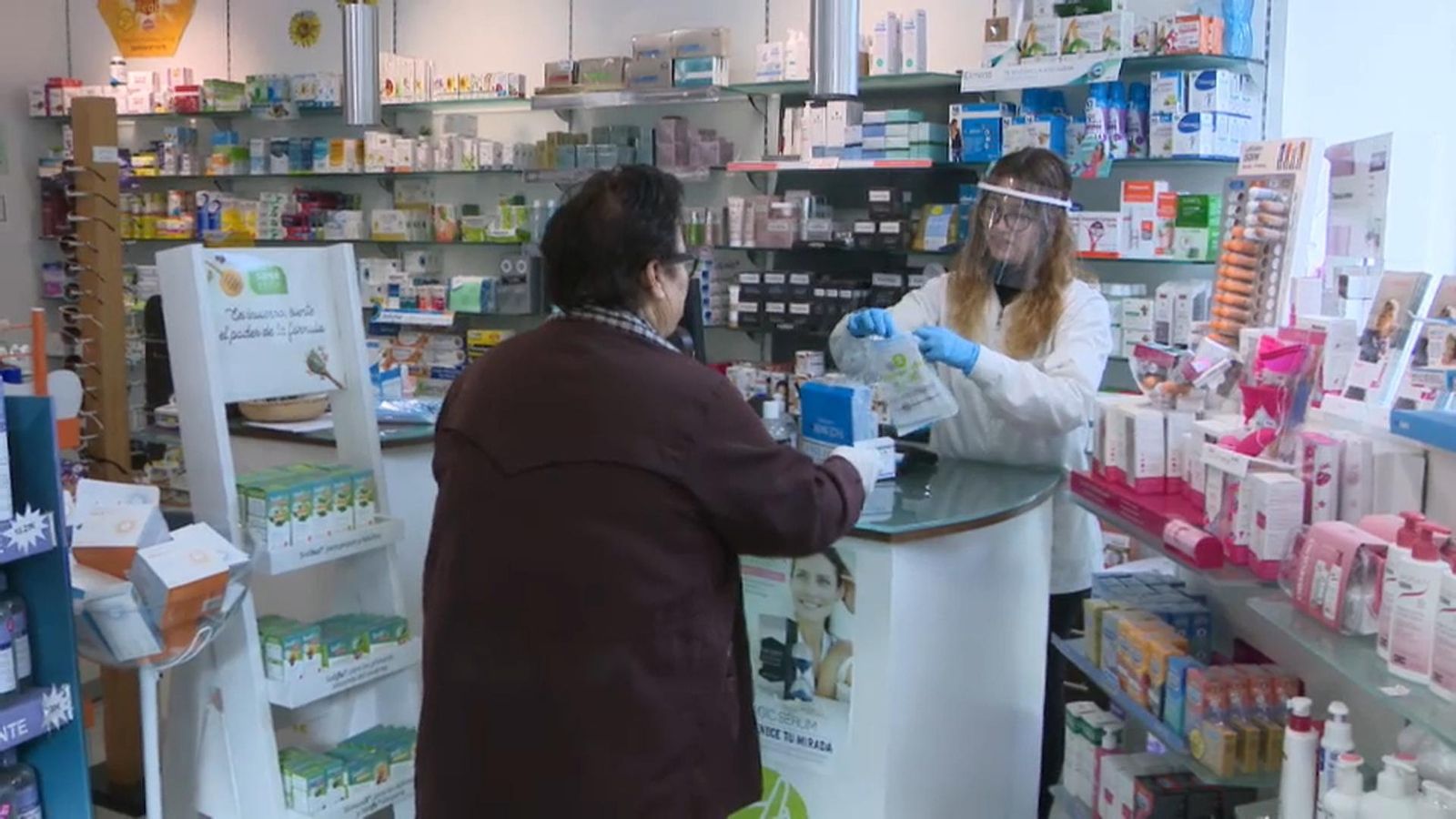 Imatge de portada: Una dona arreplega una mascareta en una farmàcia de Castelló