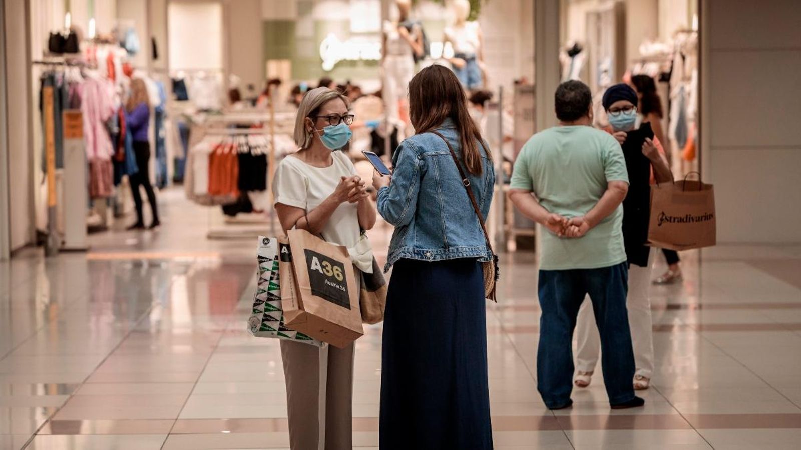 Diverses persones realitzen compres en un centre comercial amb mascaretes
