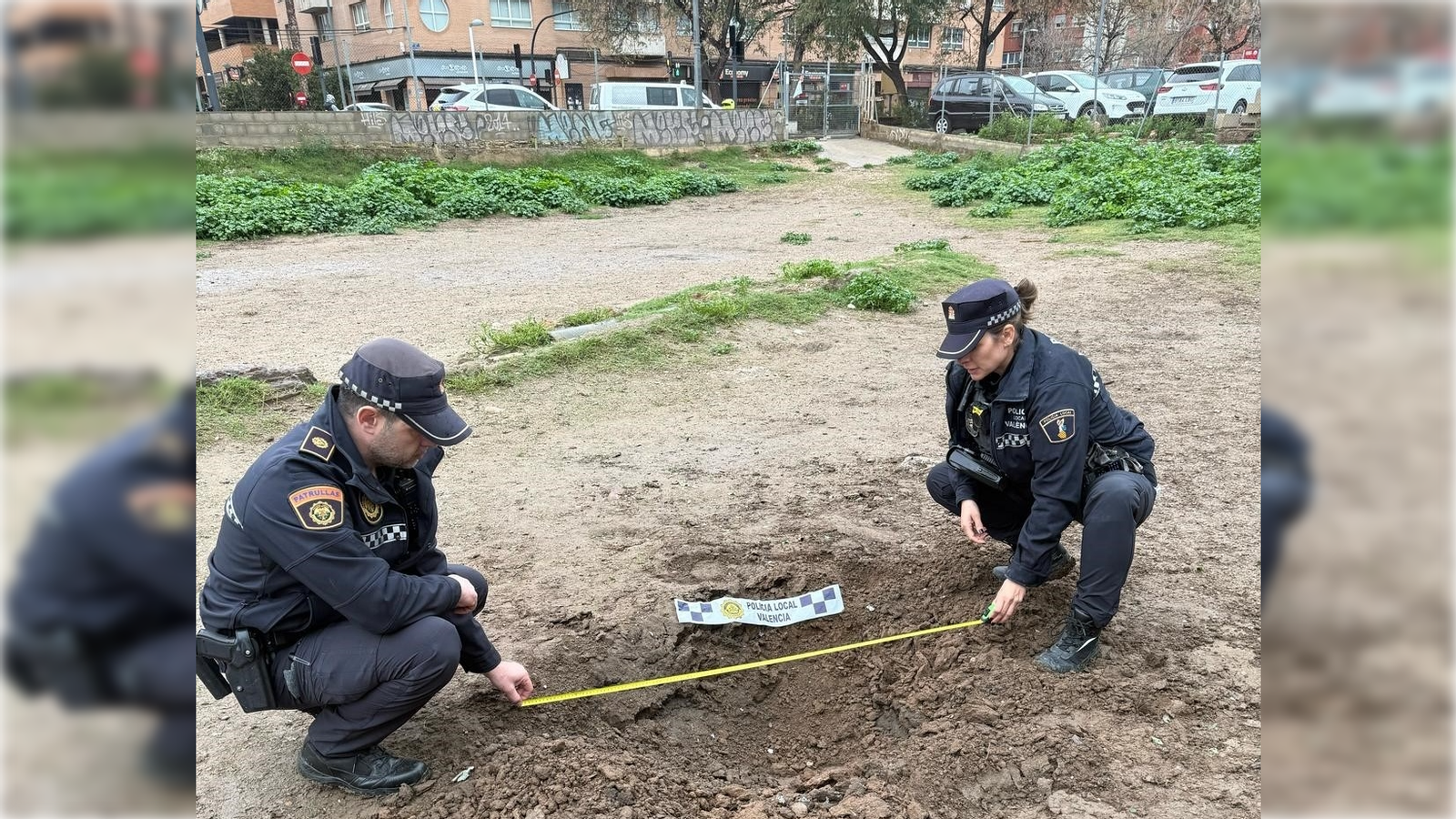 Dos agents de la Policia Local mesuren el clot obert al costat del carrer Lebon