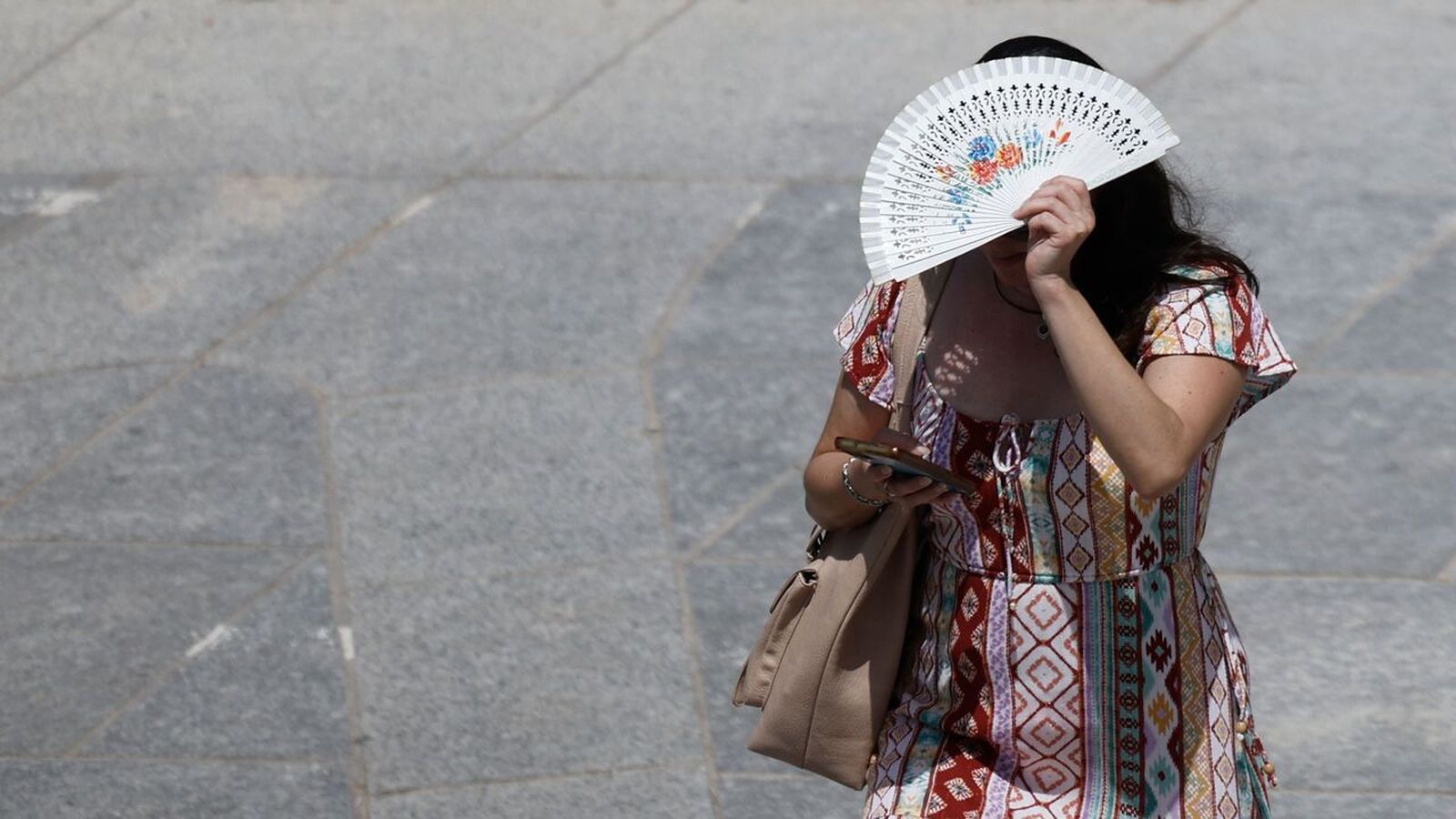 Una dona es protegix del sol amb un palmito a València