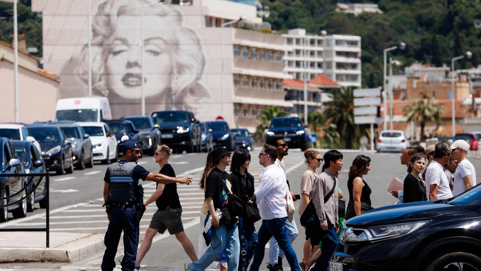 Un policia dirigeix el trànsit en un pas de vianants a Cannes