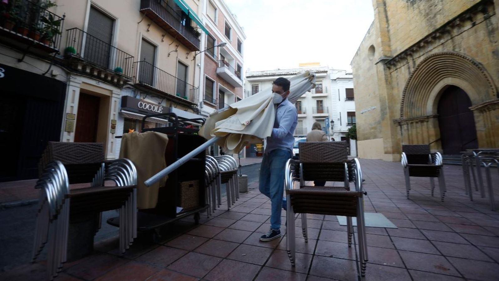 Un treballador de l’hoteleria arreplega el mobiliari d’una terrassa a Còrdova, després que el govern autonòmic haja incrementat les restriccions