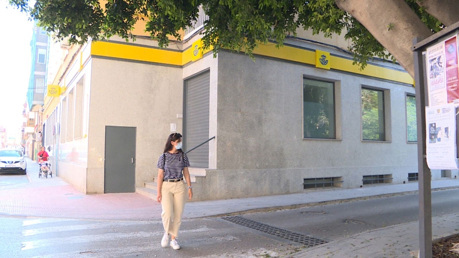 Una persona passa per davant de l'oficina de correus a Novelda