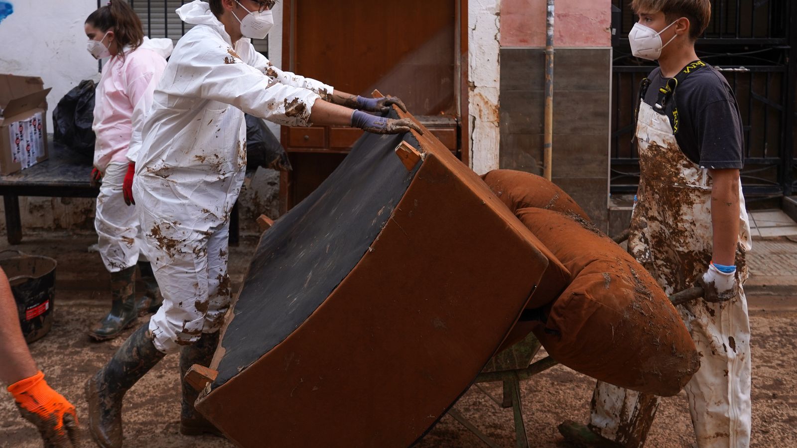 Dos joves voluntaris ajuden a netejar un carrer durant la dana a Aldaia