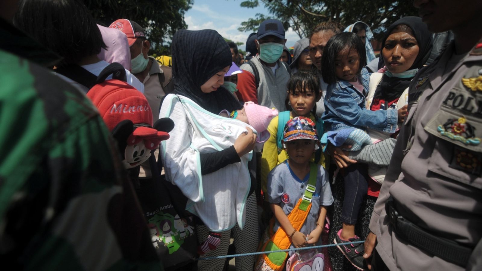 Un grup de residents esperen a bord d'un avió militar per a l'evacuació a l'aeroport de Palu