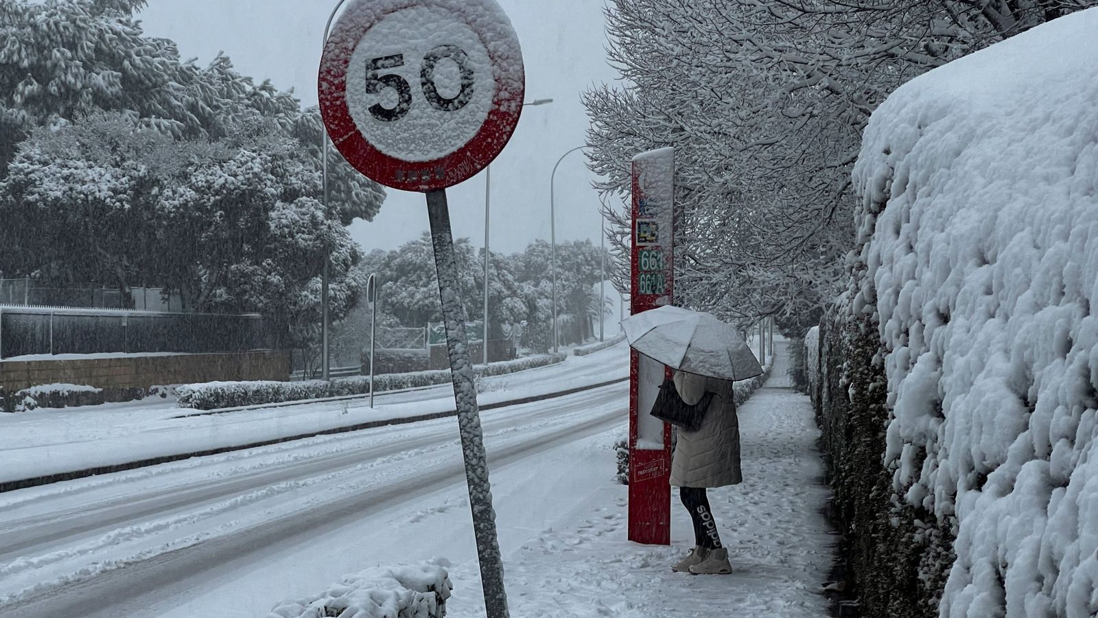 Una dona es protegix de la neu este dimecres a Galapagar, Madrid