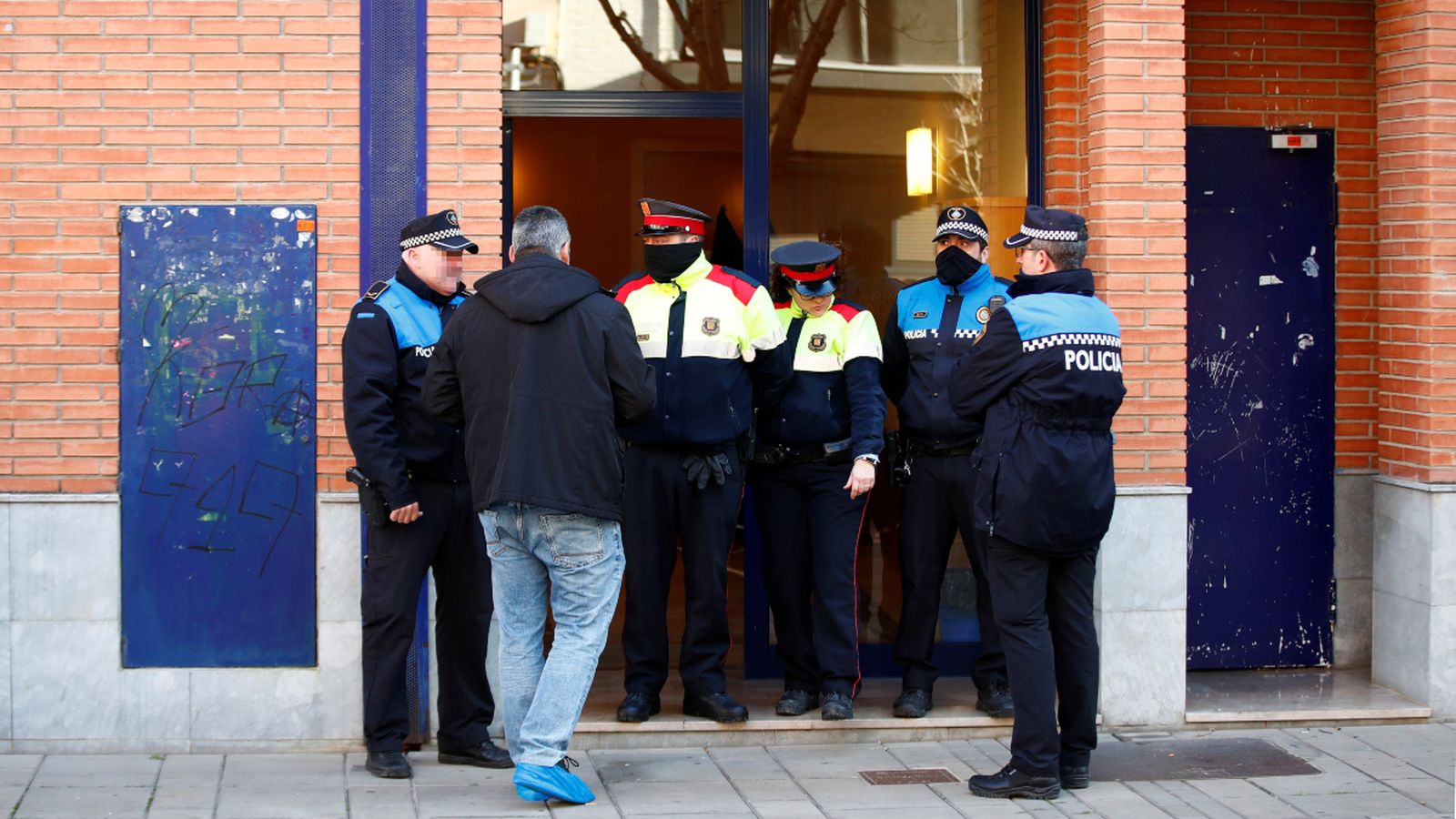Agents policials vigilen l'accés a l'edifici d'Esplugues de Llobregat on va ocórrer el crim el passat 6 de gener