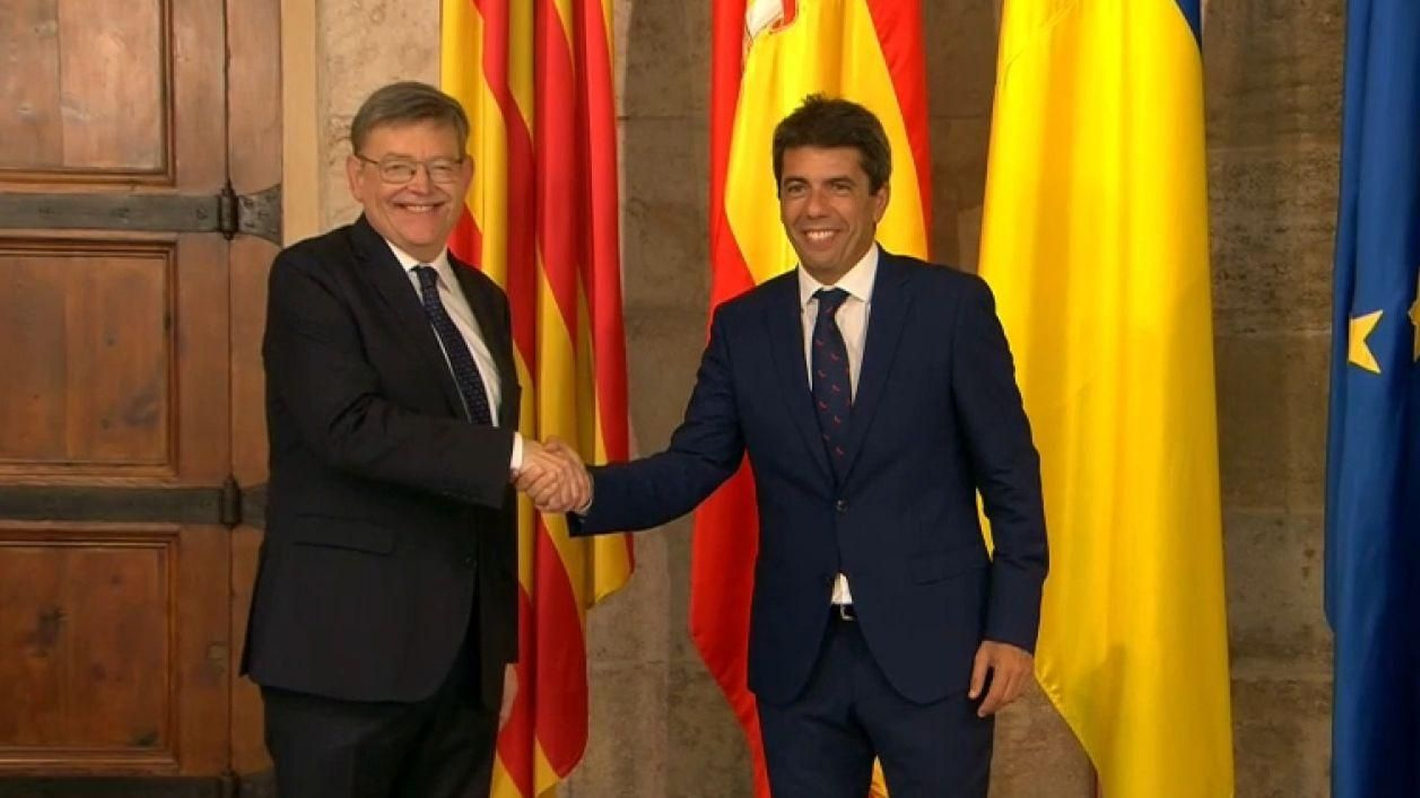 L'expresident Ximo Puig i el nou cap del Consell, Carlos Mazón, formalitzen en una encaixda les mans al palau de la Generalitat el traspàs de poder