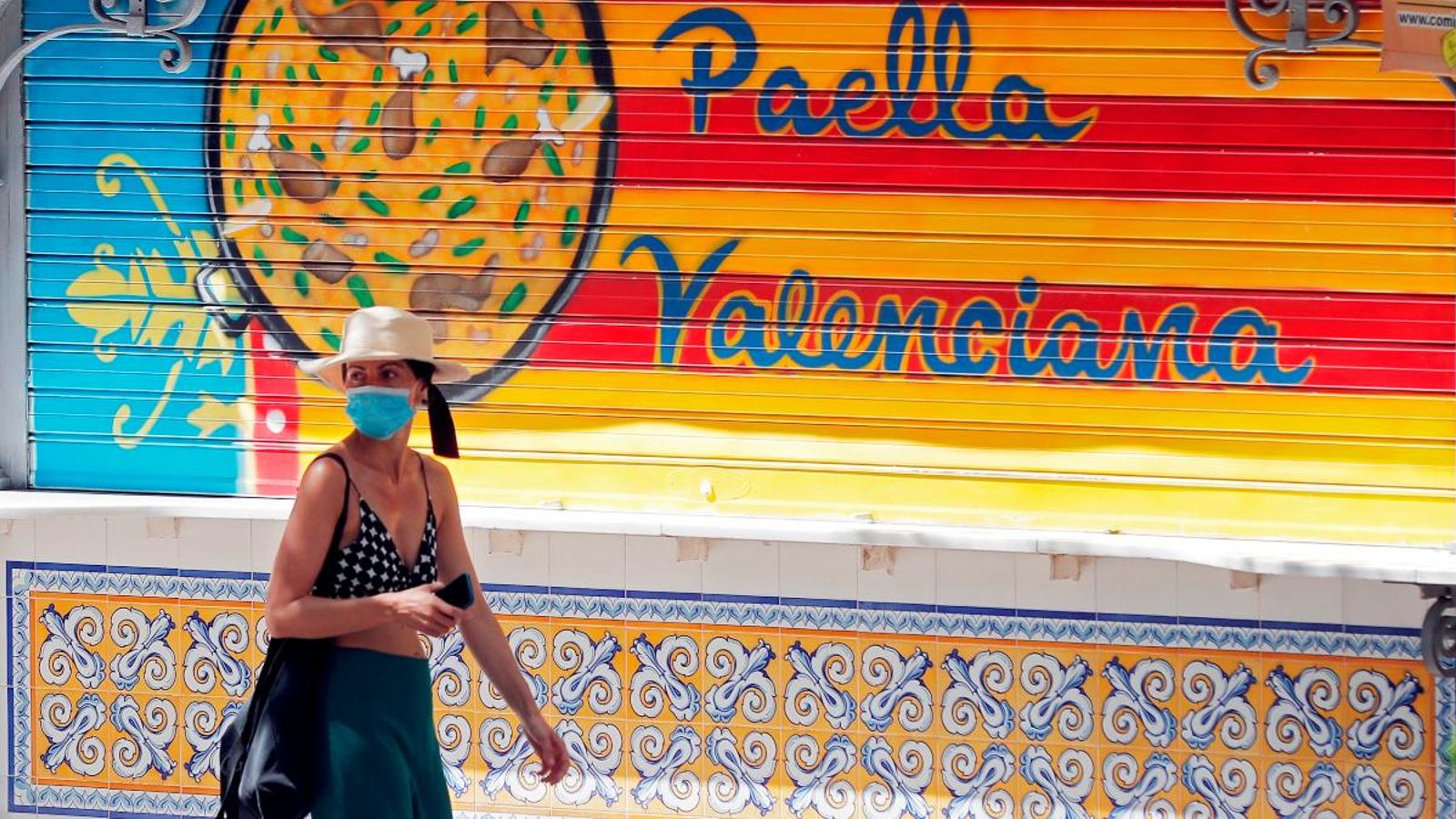 Una persona passa davant un establiment tancat de paelles