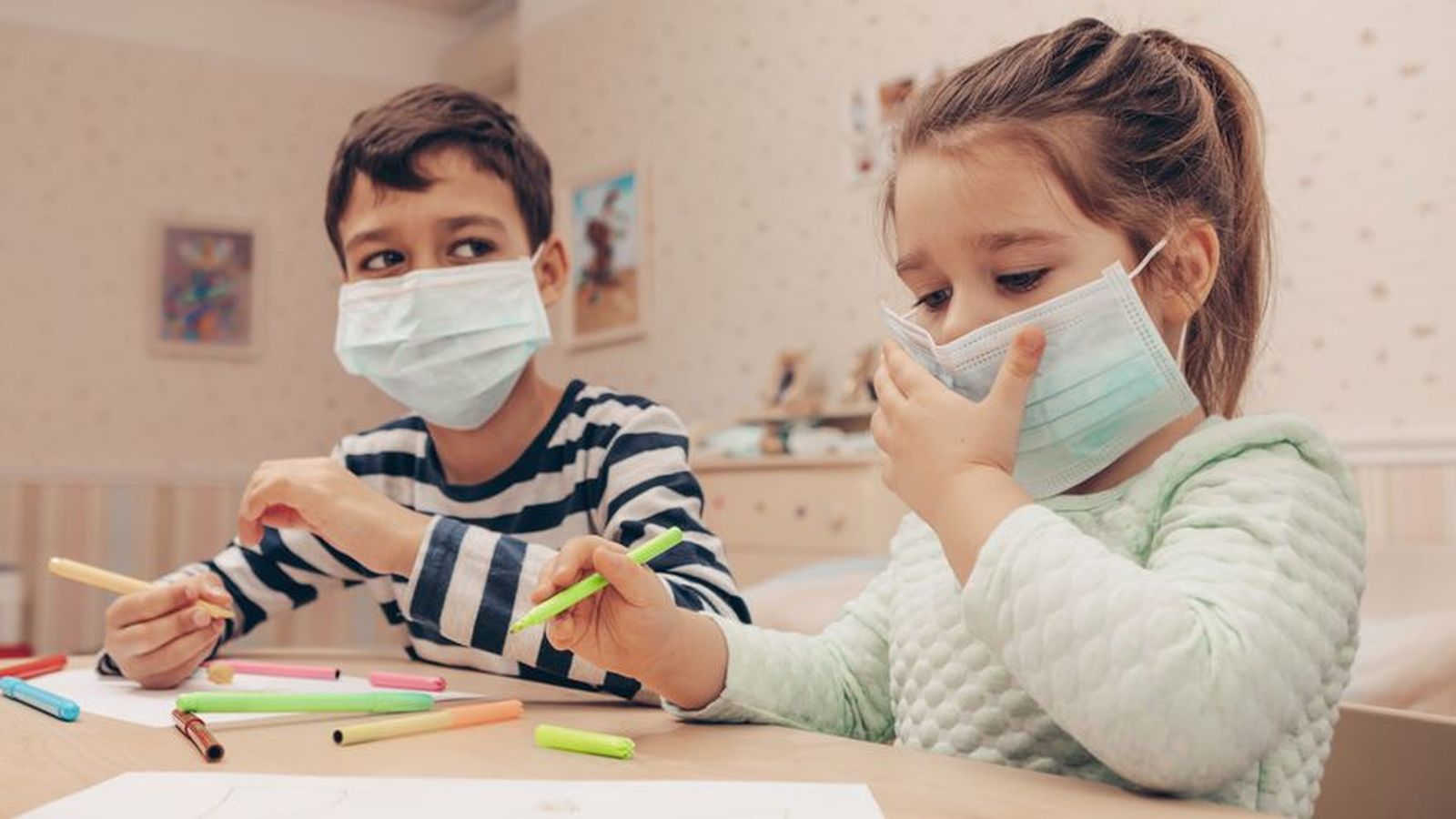 Dos xiquets amb mascareta fan quarantena a casa, en una imatge d'arxiu