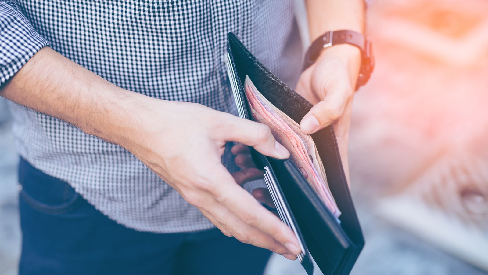 Un home trau diners de la cartera