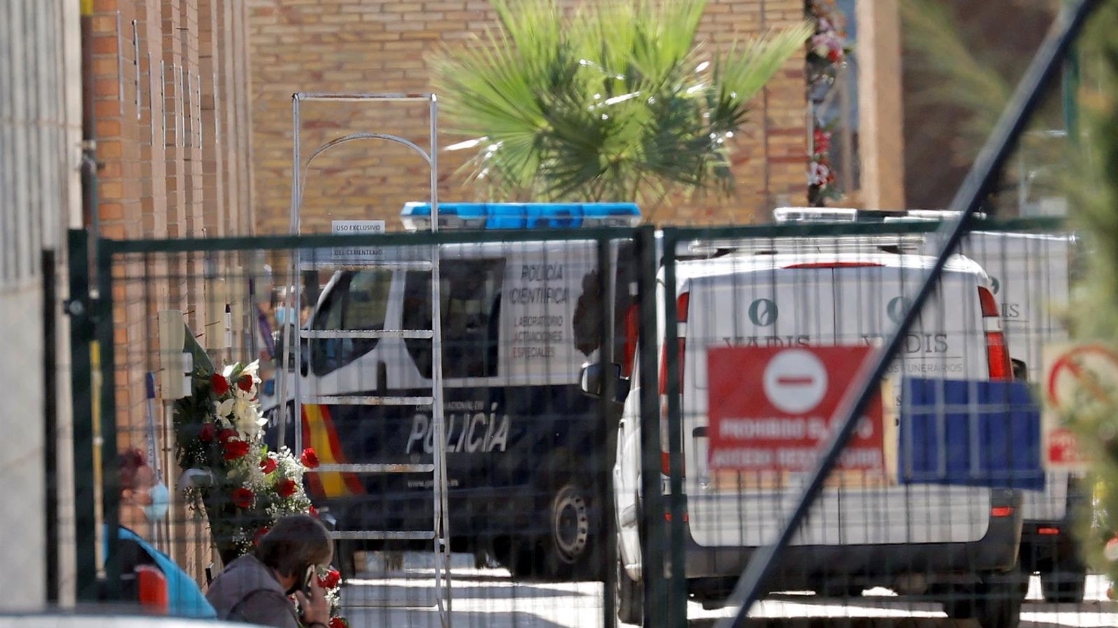 Un furgó policial i dos vehicles funeraris a l'interior del cementeri de Torrent