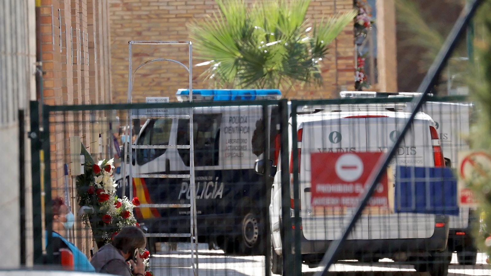 Un furgó policial i dos vehicles funeraris a l'interior del cementeri de Torrent