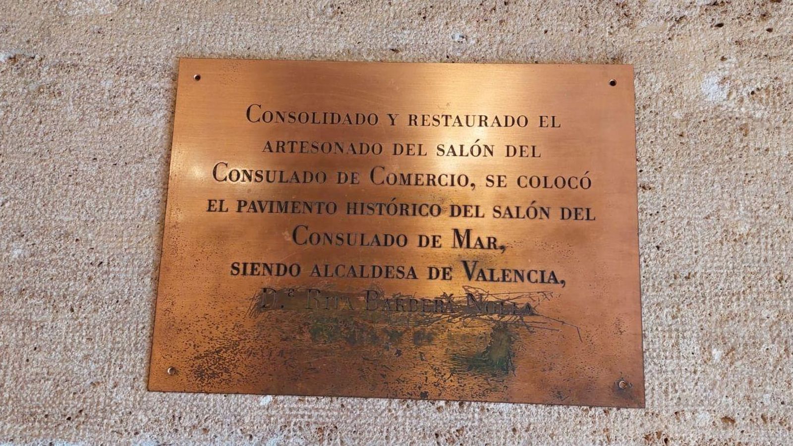 Placa fins ara ancorada al mur de la Llotja de València, que el govern municipal ha retirat