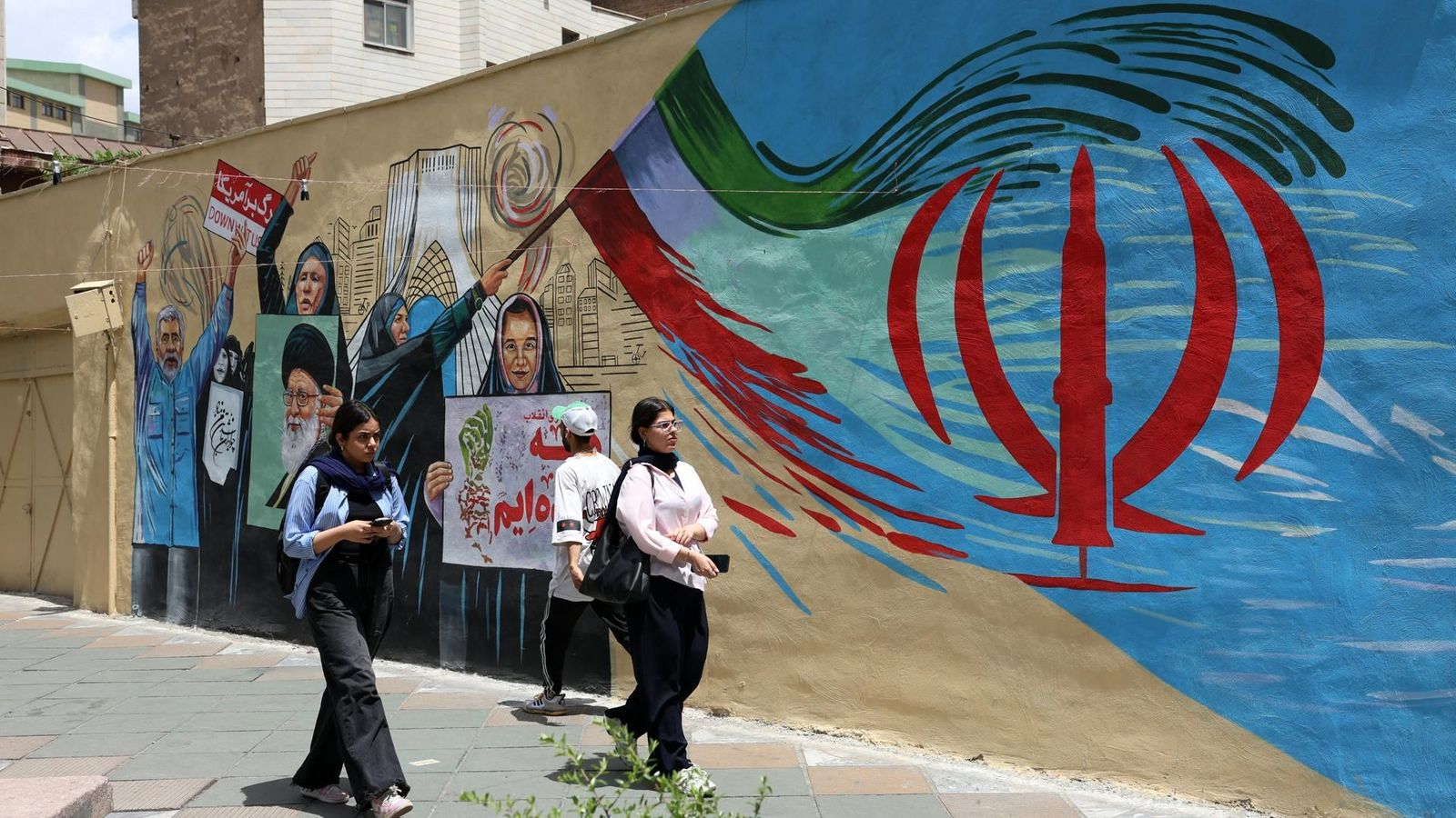 Dos dones passen per davant d'un mural a Teheran en una jornada en què els Estats Units ha bombardejat la capital i algunes ciutats del sud del país