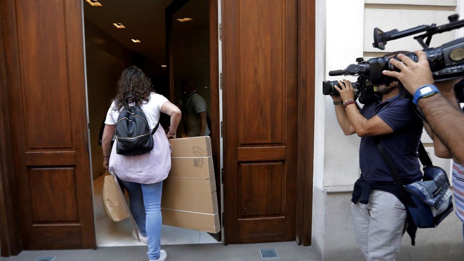 Una agent de la Unitat Central Operativa (UCO) de la Guàrdia Civil, entra al domicili d'Eduardo Zaplana amb caixes de cartró per emmagatzemar el material que pugui ser intervingut